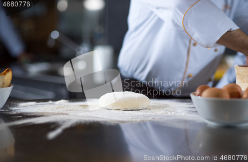 Image of chef hands preparing dough for pizza
