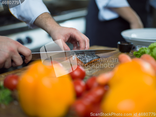 Image of Chef hands preparing marinated Salmon fish