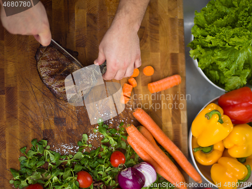 Image of closeup of Chef hands preparing beef steak