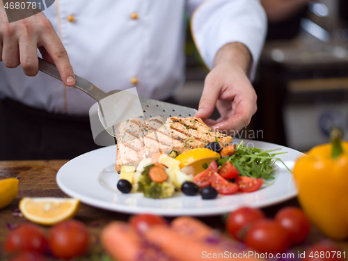 Image of cook chef decorating garnishing prepared meal