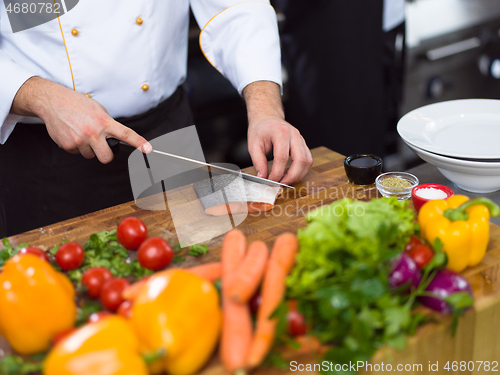 Image of Chef hands preparing marinated Salmon fish