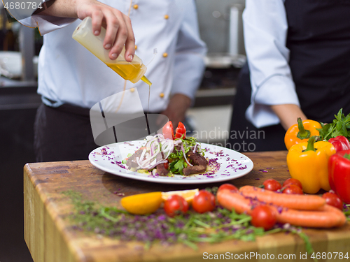 Image of Chef finishing steak meat plate