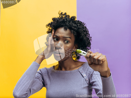 Image of young woman looking on pregnancy test