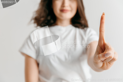 Image of Woman\'s hand with finger on gray background