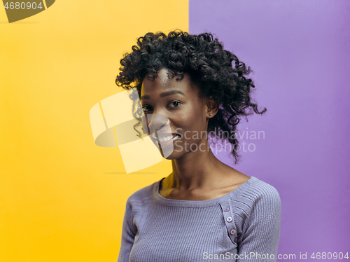 Image of The happy african woman standing and smiling against gray background.