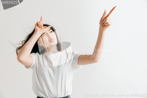 Image of Losers go home. Portrait of angry woman showing loser sign over forehead