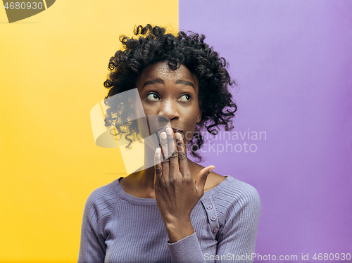 Image of The young woman whispering a secret behind her hand