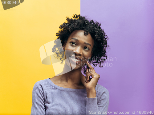 Image of The happy african woman standing and smiling against gray background.