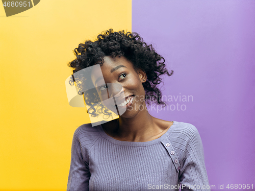 Image of The happy african woman standing and smiling against gray background.