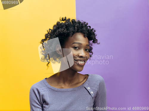 Image of The happy african woman standing and smiling against gray background.