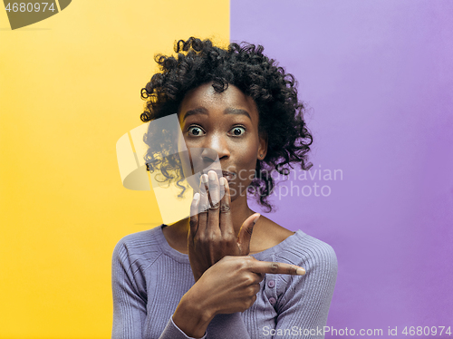 Image of The young woman whispering a secret behind her hand