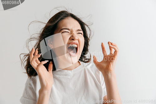 Image of The young emotional angry woman screaming on gray studio background