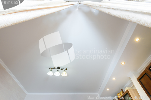 Image of Two-level ceiling with a small chandelier in the interior of the room