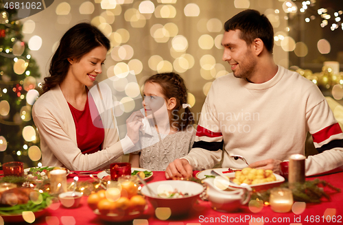 Image of happy family having christmas dinner at home