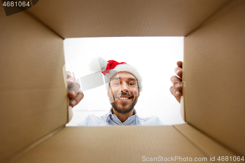 Image of happy man opening parcel box or christmas gift