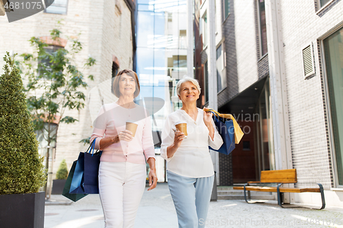 Image of senior women with shopping bags and coffee in city