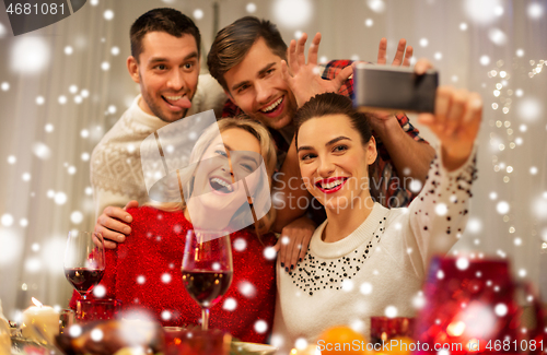 Image of friends taking selfie at christmas dinner