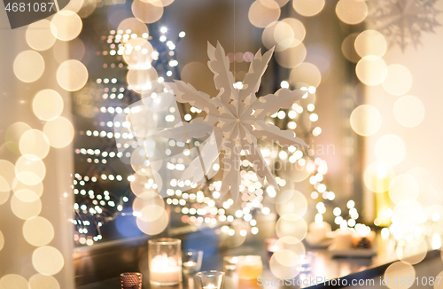 Image of paper snowflake decoration hanging on window