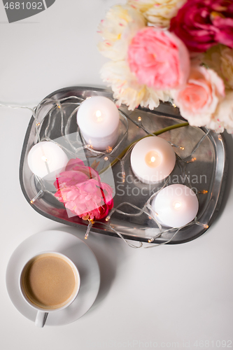 Image of coffee, candles, garland and flowers on table