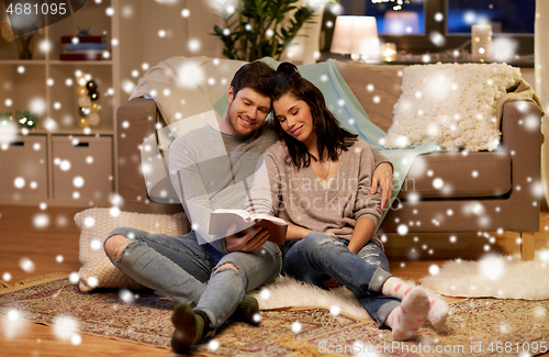 Image of happy couple reading book at home