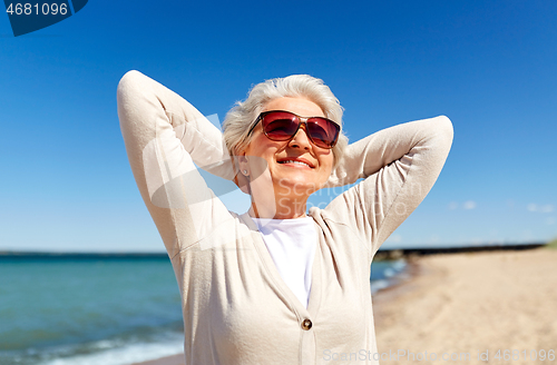 Image of portrait of senior woman in sunglasses on beach