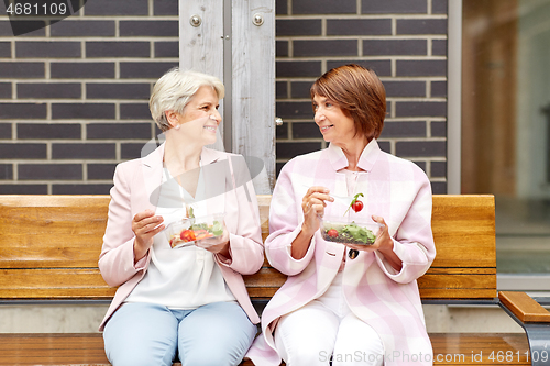 Image of senior women eating takeaway food on city street