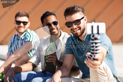 Image of men drinking beer and taking selfie by smartphone