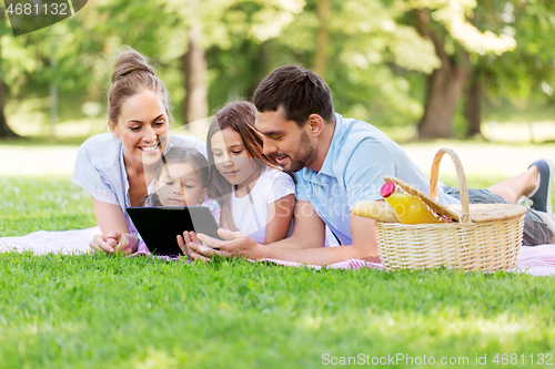 Image of family with tablet pc on picnic in summer park