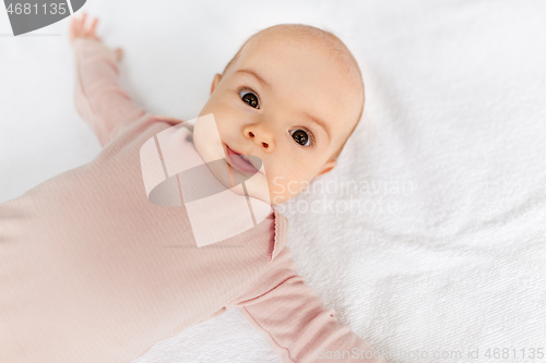 Image of sweet baby girl lying on white blanket