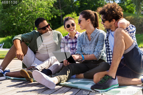 Image of friends with tablet pc computer outdoors in summer