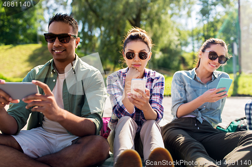 Image of friends with smartphones at summer park