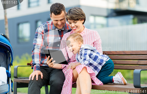 Image of family with tablet pc sitting on bench in city