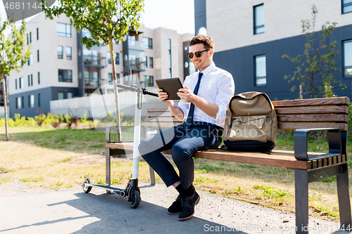 Image of businessman with tablet computer, bag and scooter