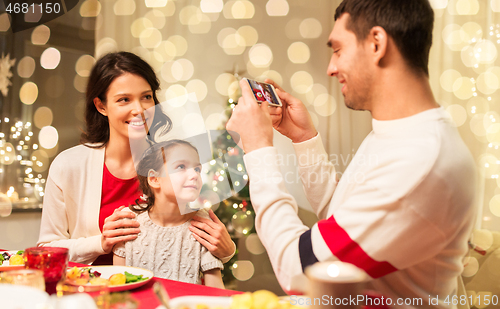 Image of happy family taking picture at christmas dinner