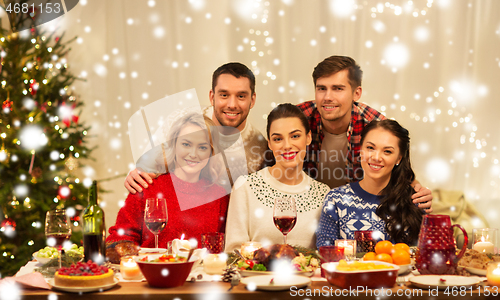 Image of happy friends celebrating christmas at home