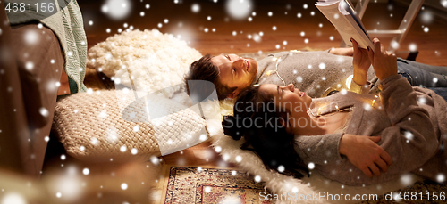 Image of happy couple reading book at home