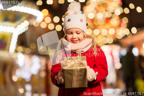 Image of happy girl with gift box at christmas market