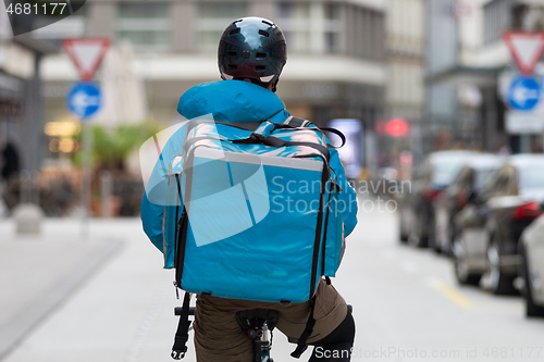 Image of Courier On Bicycle Delivering Food In City.