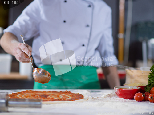 Image of Chef smearing pizza dough with ketchup