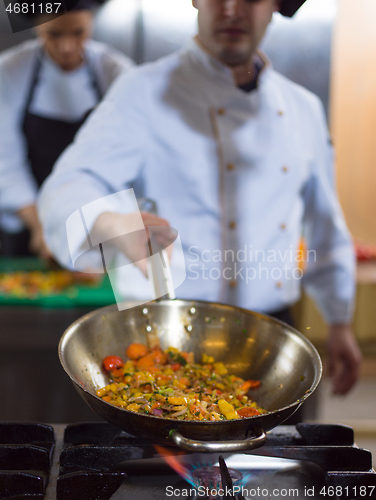 Image of chef flipping vegetables in wok