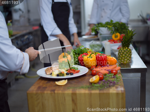 Image of cook chef decorating garnishing prepared meal