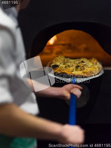 Image of chef removing hot pizza from stove