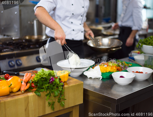 Image of Chef hands serving spaghetti