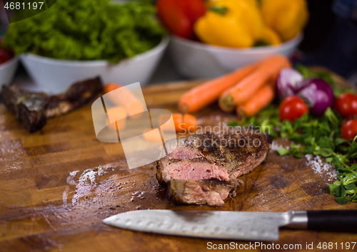 Image of Juicy slices of grilled steak on wooden board