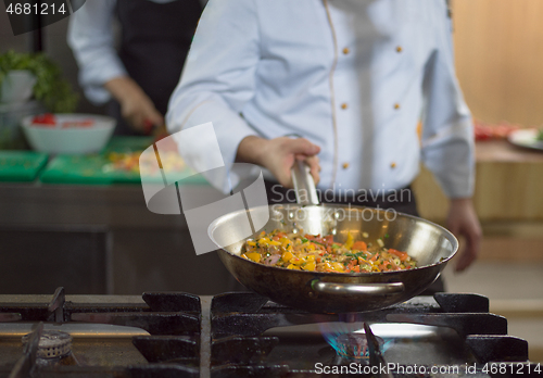 Image of chef flipping vegetables in wok