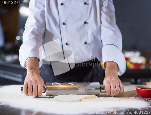 Image of chef preparing dough for pizza with rolling pin