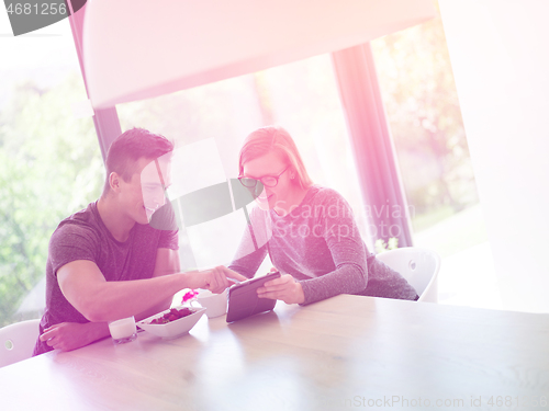 Image of couple enjoying morning coffee and strawberries