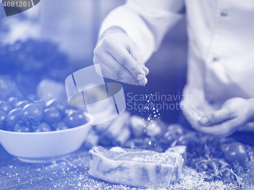 Image of Chef putting salt on juicy slice of raw steak