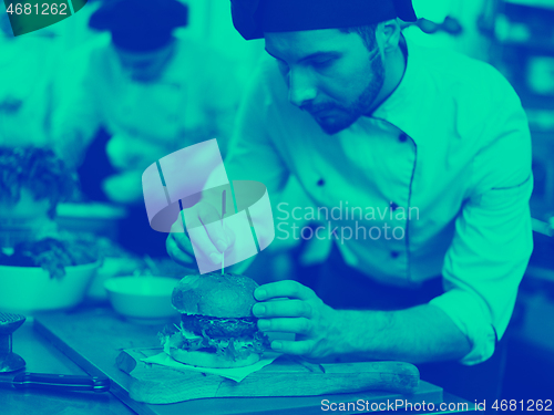 Image of chef finishing burger