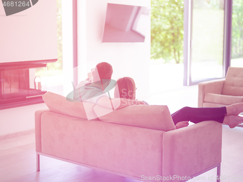 Image of Young couple on the sofa watching television